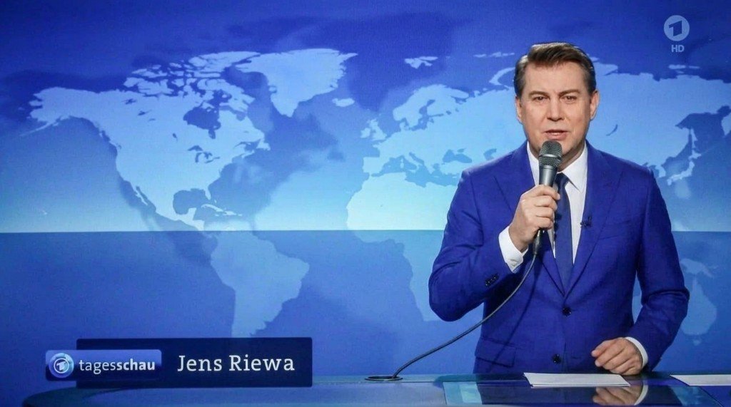 Jens Riewa im Tagesschau-Studio mit einem kabelgebundenen Handmikrofon